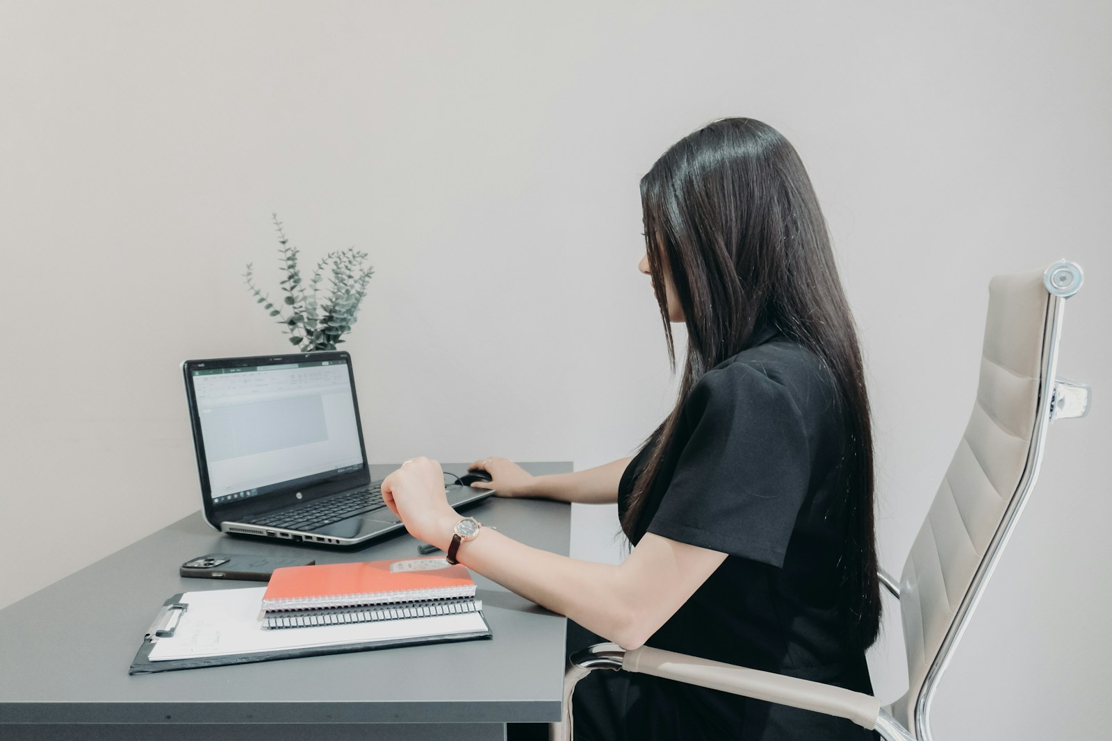 A person working at a laptop placed below eye level, the position behind most desk-related neck pain